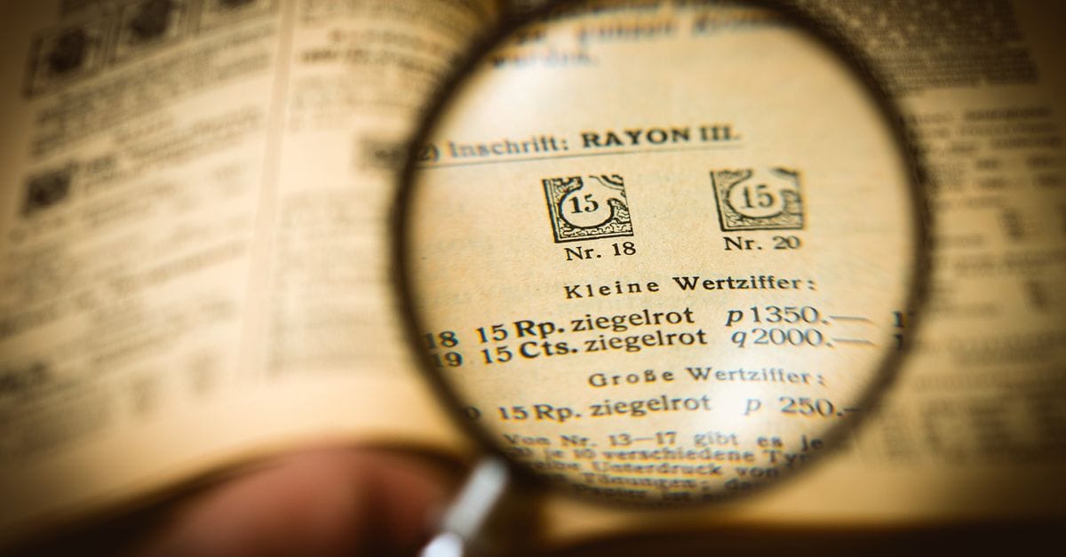 Detailed view of a book page magnified by a glass, enhancing text clarity.