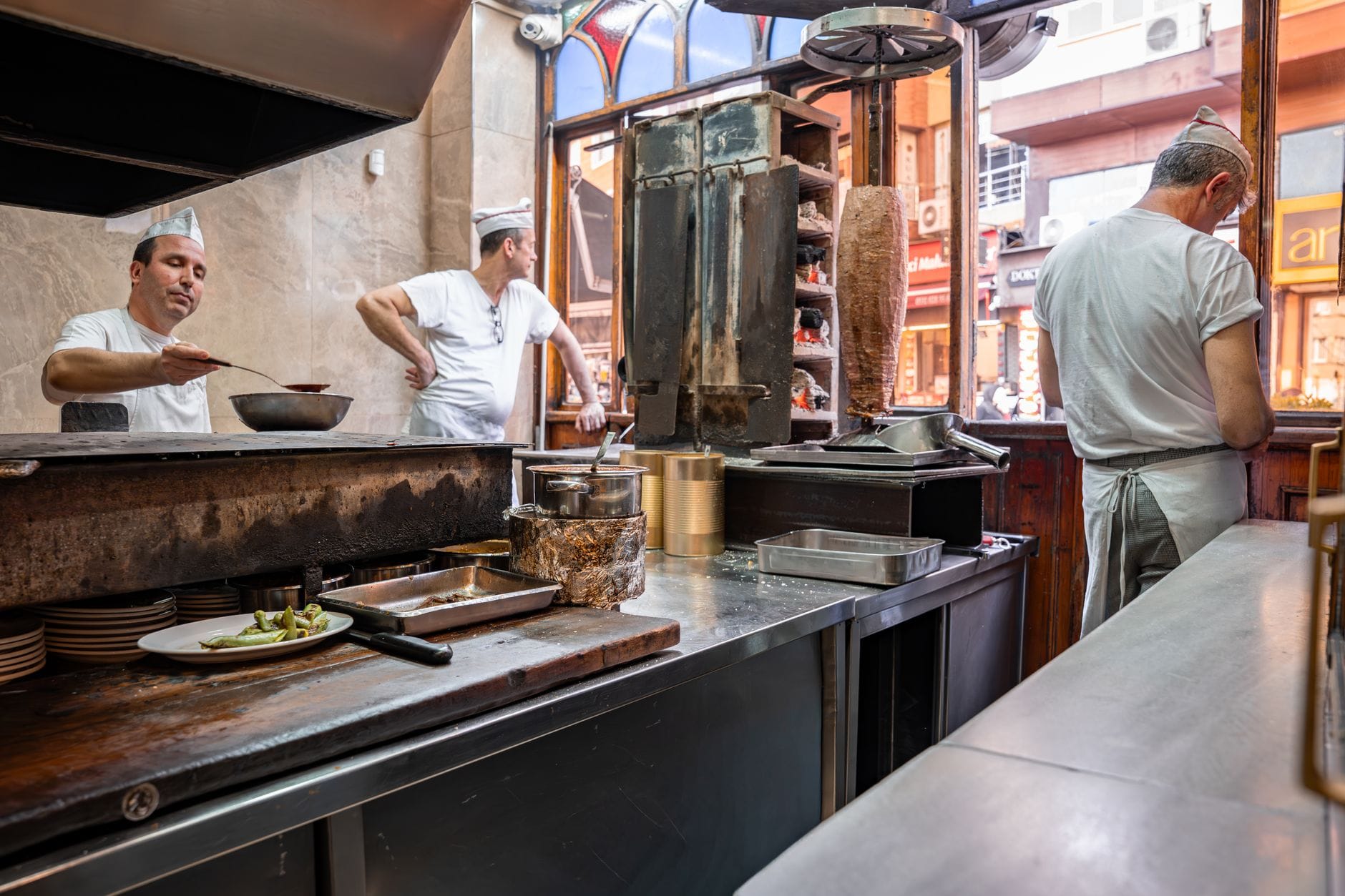 A bustling scene inside a Turkish döner shop kitchen in Bursa, Türkiye, showcasing culinary preparations.