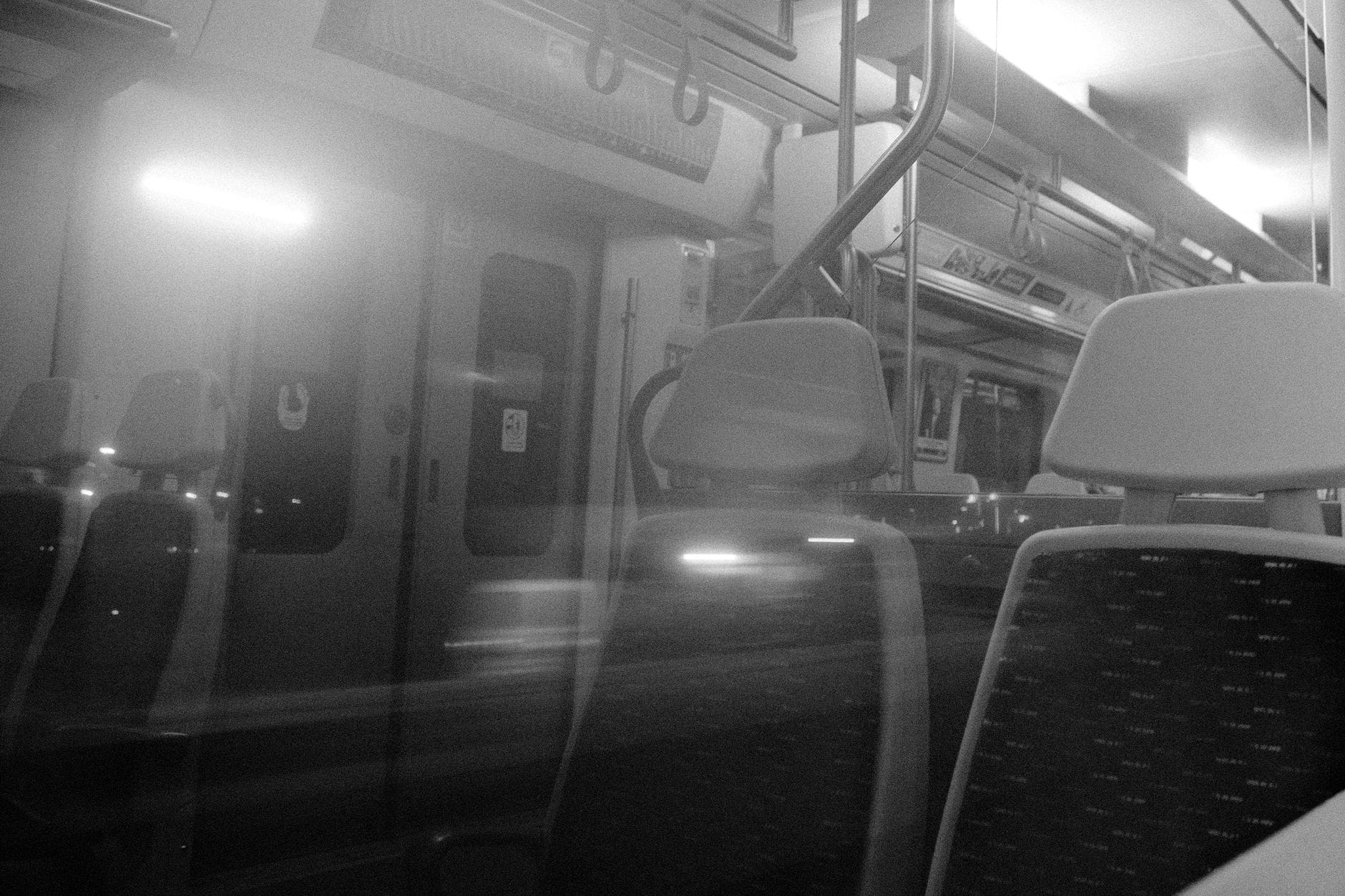 Ethereal view of an empty train interior captured in black and white.