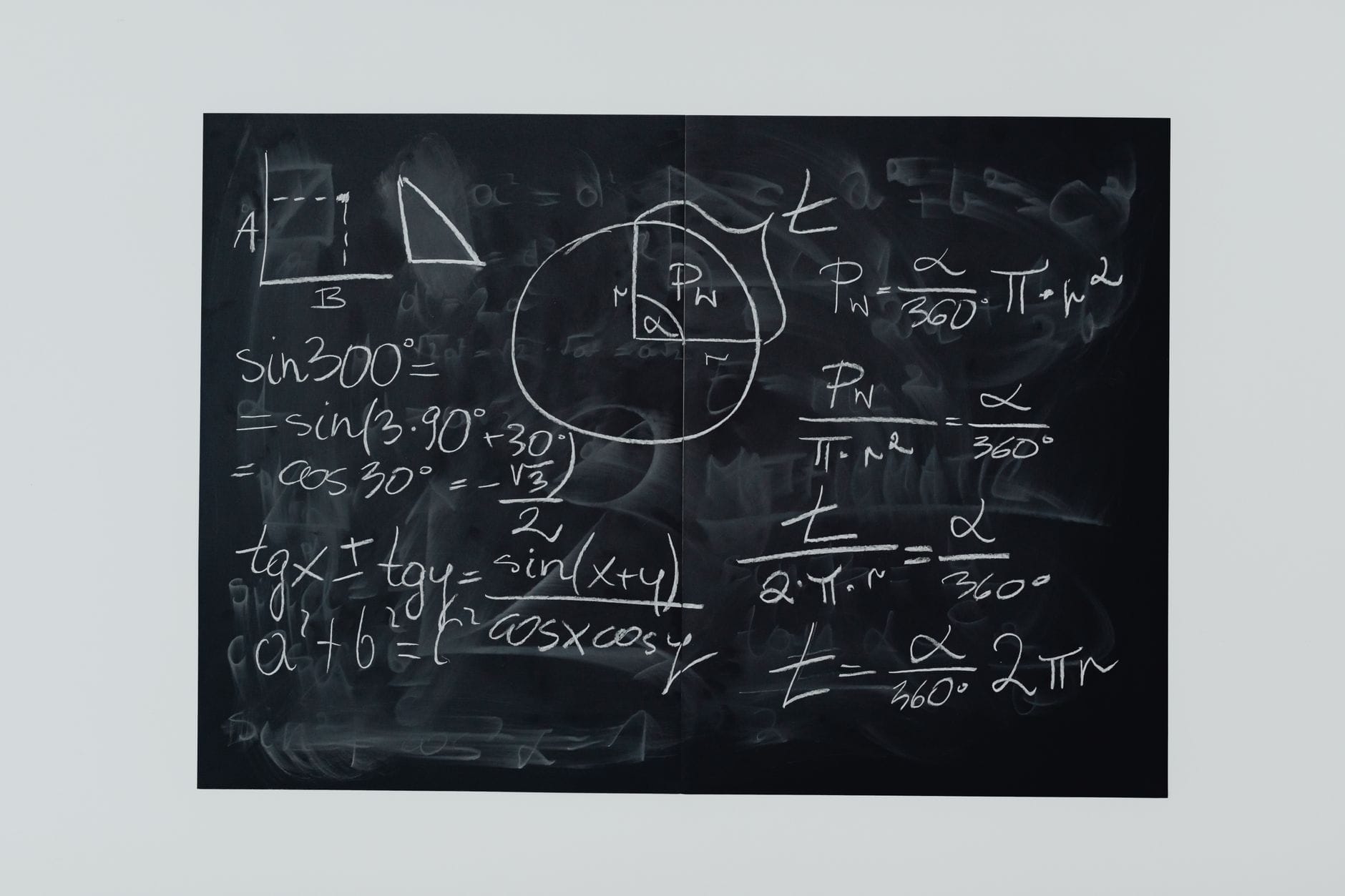 Detailed view of mathematical equations and diagrams on a blackboard.