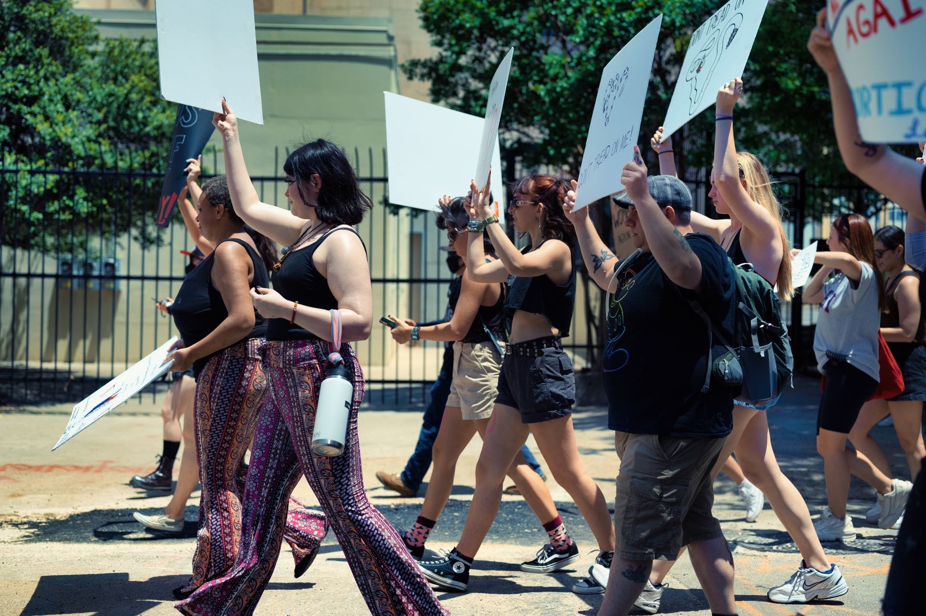 A diverse group of activists protesting outdoors, holding placards and engaging in social activism.