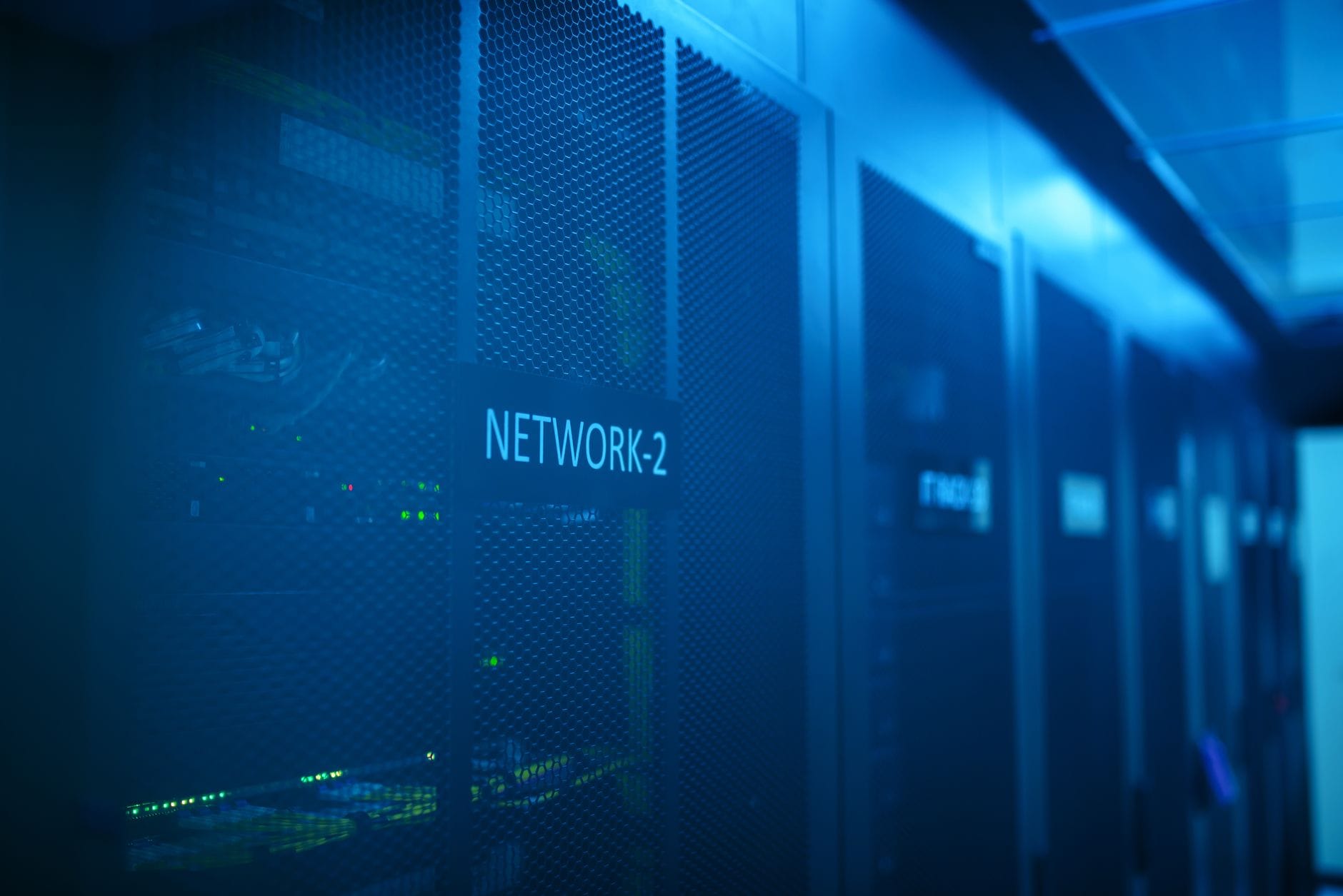 A modern server room featuring network equipment with blue illumination.